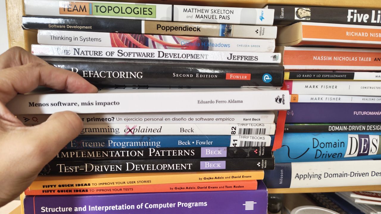 Mi mano coloca Menos software, más impacto, de Eduardo Ferro Aldama, entre los libros de ingeniería de mi estantería.